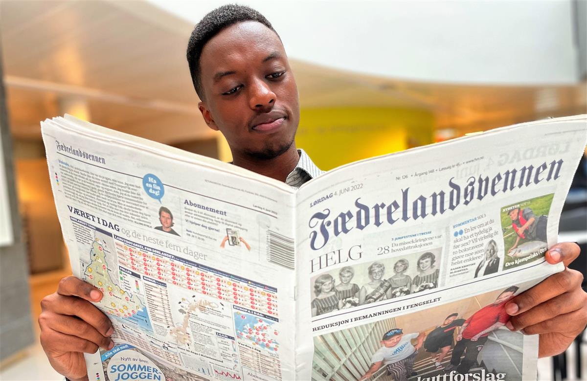 Ung mann leser Fædrelandsvennen - Klikk for stort bilde