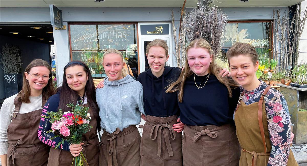 Seks kvinner foran blomsterbutikk - Klikk for stort bilde