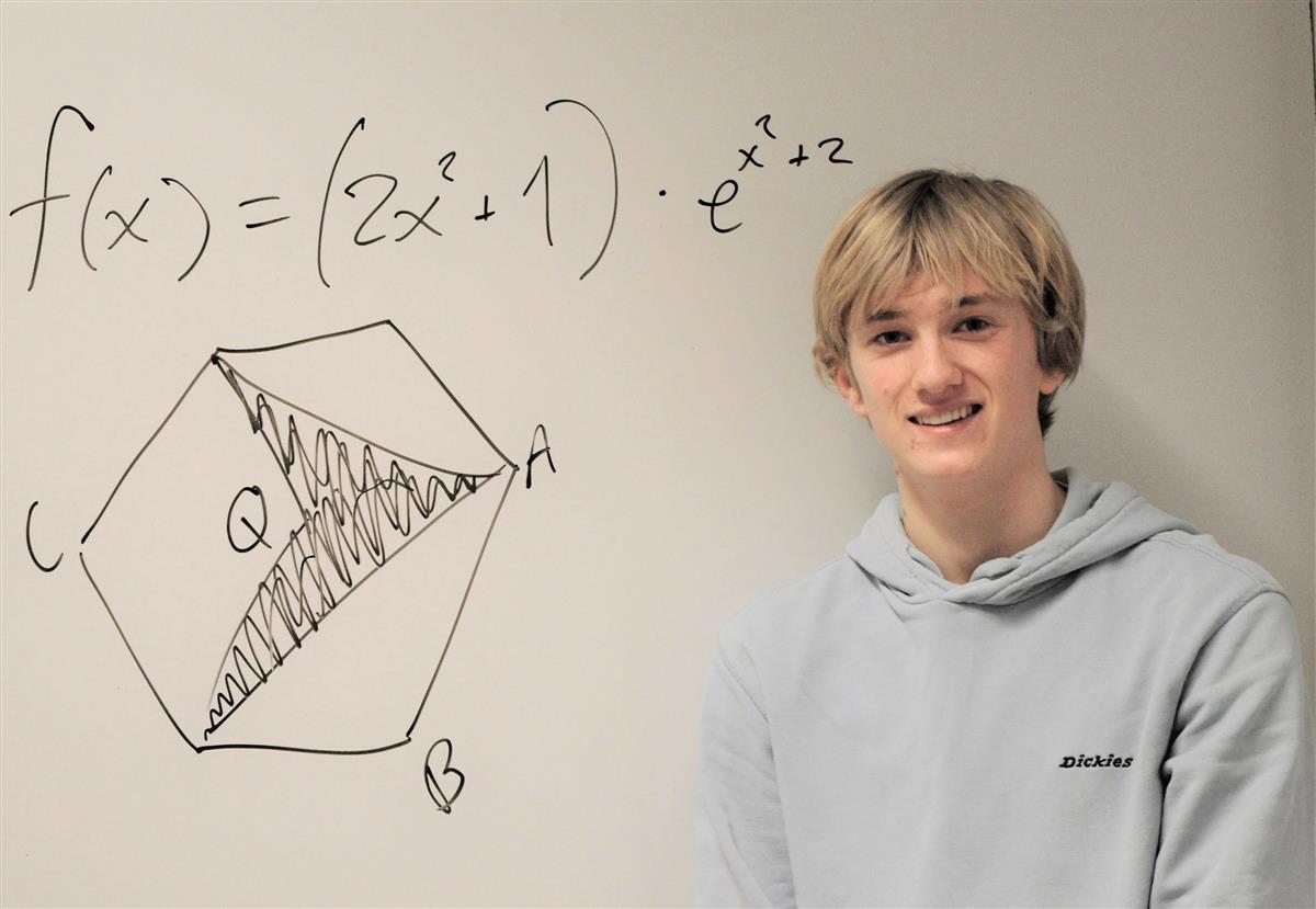 Ung mann foran tavle med regnestykke - Klikk for stort bilde